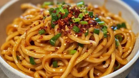 Delicious bowl of spicy garlic chili noodles with vibrant toppings