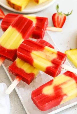 Colorful Lava Flow Popsicles with fruit layers in a sunny setting.