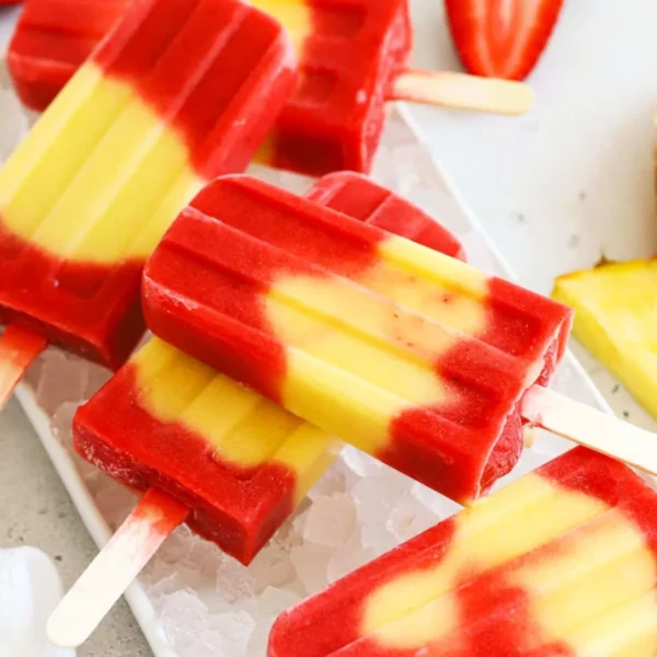 Colorful Lava Flow Popsicles with fruit layers in a sunny setting.
