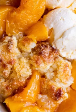 Freshly baked peach cobbler topped with a golden crust and served warm