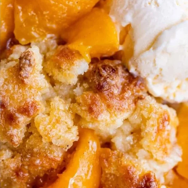 Freshly baked peach cobbler topped with a golden crust and served warm