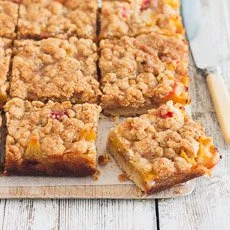 Peaches and Cream Crumble Bars topped with fresh peaches and creamy filling