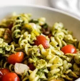Colorful pesto pasta salad with fresh ingredients and vibrant greens