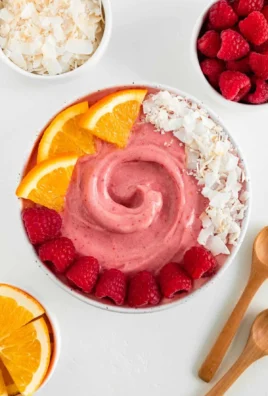 Delicious Raspberry Orange Smoothie Bowl topped with fresh fruits and granola.