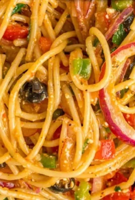 Colorful spaghetti salad with fresh vegetables and dressing